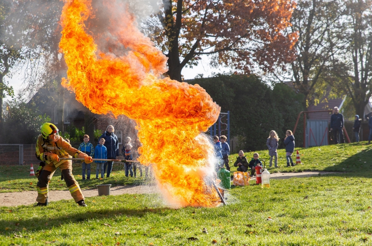 Im Rahmen der Brandschutzerziehung präsentieren Martin und Matthias Hemming von der Freiwilligen Feuerwehr Feldhausen, was passiert, wenn man Wasser auf brennendes Öl gießt.