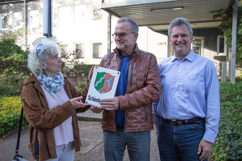Maria Reidick-Rominski übergibt ein Schild an Jörg Middelhoff (m.). Magnus Thesing steht dabei.