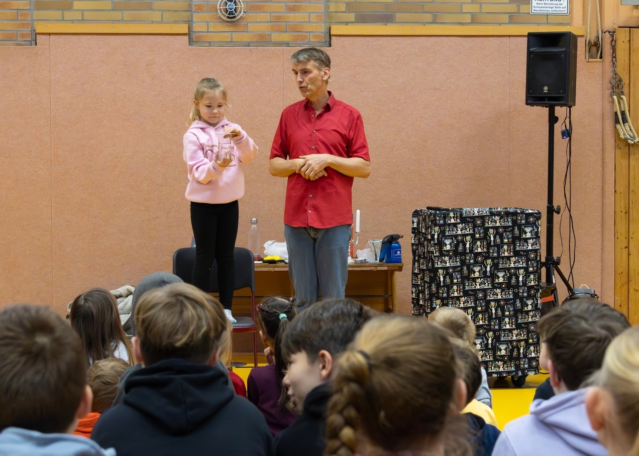 Mitten im Experiment: Eine Schülerin unterstützt Dr. Sascha Ott aktiv. Die Kinder wurden immer wieder in die Wissenschaftsshow eingebunden.