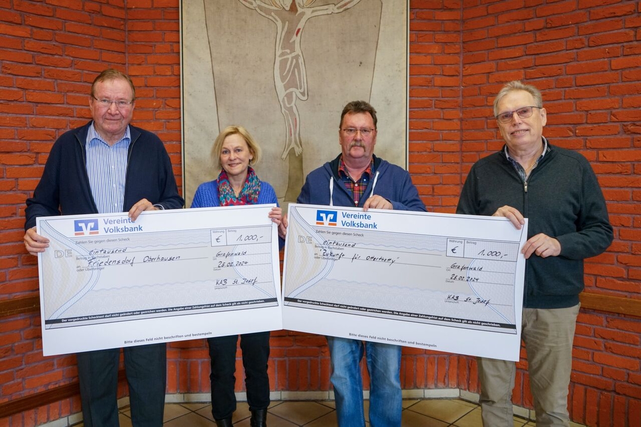 Joachim Becker (l.) und Klaus Lehrich (r.) von der KAB überreichten Claudia Peppmüller (Friedensdorf Oberhausen) und Ulrich Dabrindt („Zukunft für Otterthotty“) die Schecks.