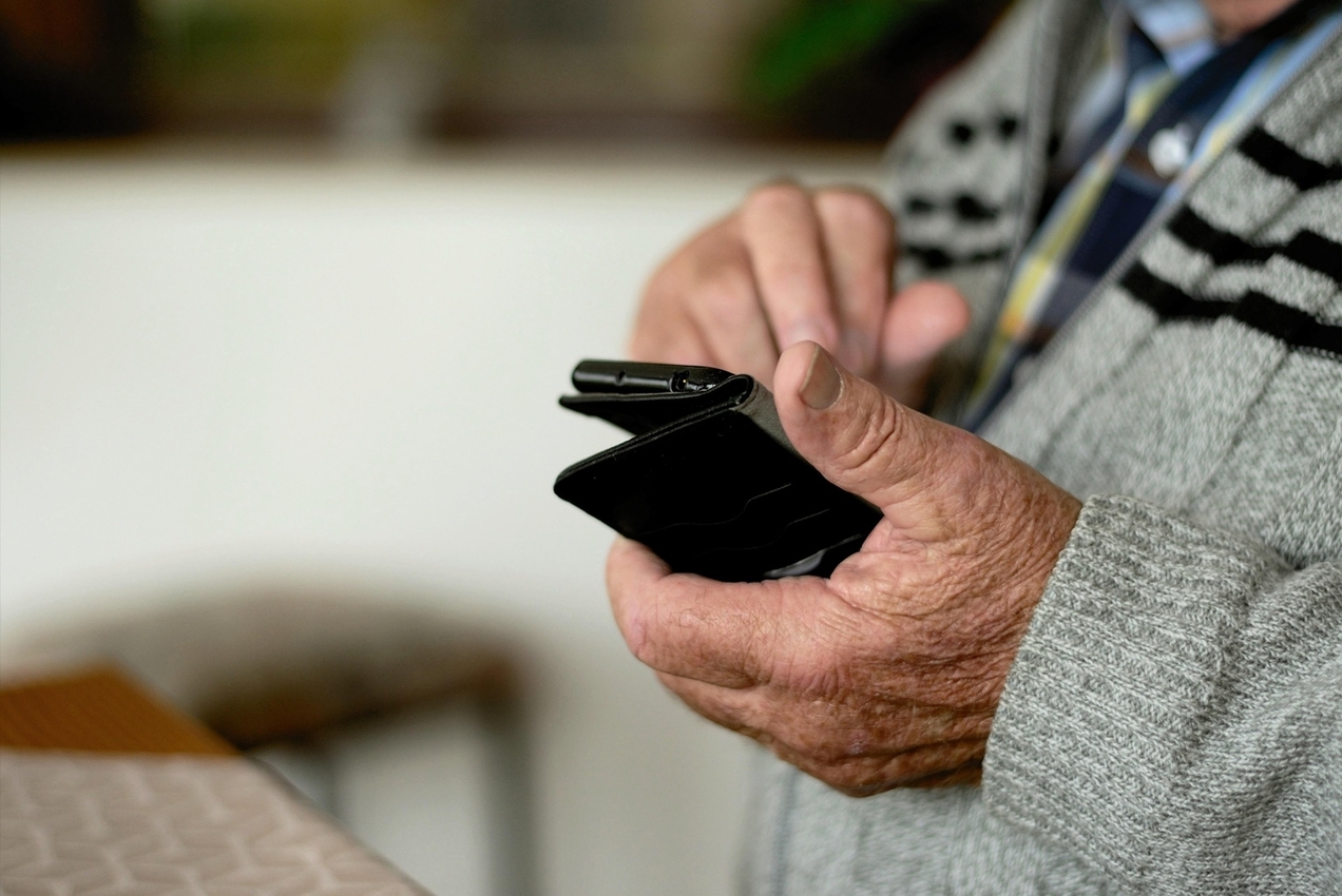 Ein Senior hält ein Handy