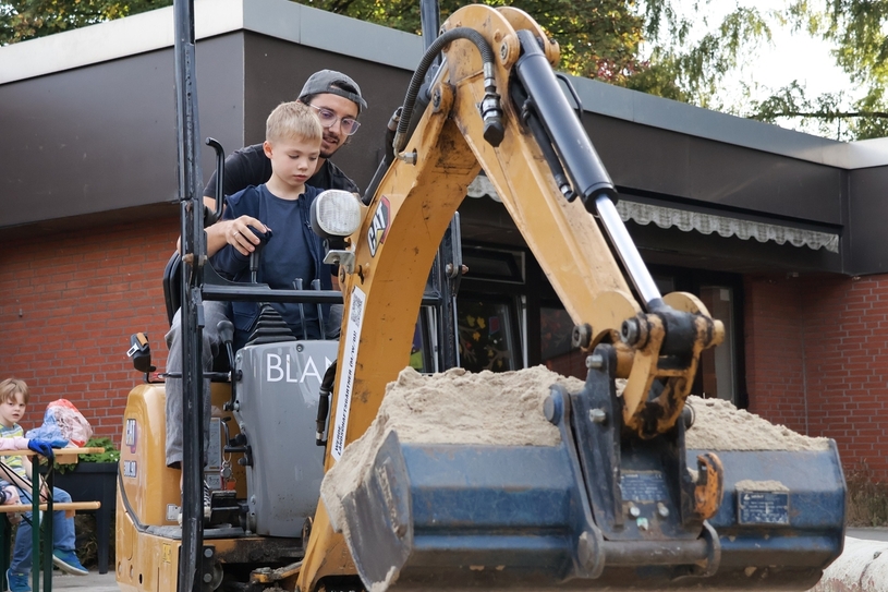 Joscha Fritzen, Landschaftsgärtner-Meister in Dirk Blaniks Unternehmen, zeigt den Vorschülern in der ev. Kita Gartenstraße das Baggerfahren.