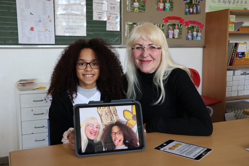 Oma Wali und die Viertklässlerin Jaydra stellten für das gemeinsame Fotobuch eine Reihe von Emojis nach, was ihnen sichtlich Spaß macht.