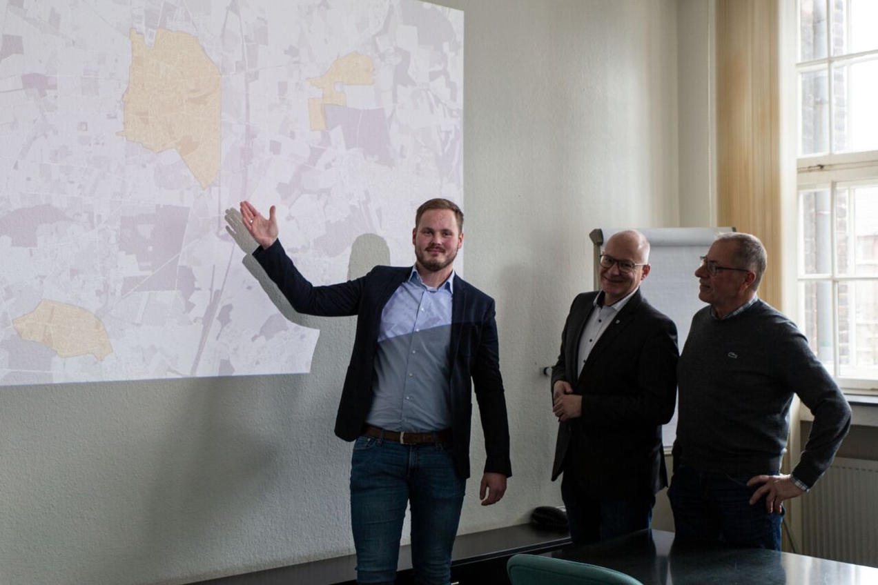 Muenet-Vertreter Denis Ebbing stellt dem Technischen Beigeordneten Klaus Müller sowie Bezirksbürgermeister Ludger Schnieder in Anwesenheit der Presse die Ausbaugebiete vor.
