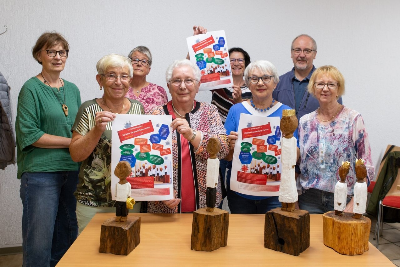 Einige ehrenamtliche Unterstützer der Caritas stellen gemeinsam das Programm für die Festwoche vor.