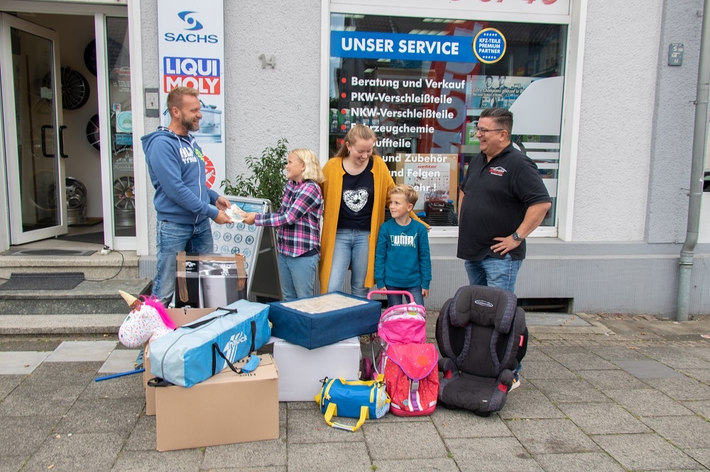 Das Bild zeigt (v.l.) Achim Petersen von der Fluthilfe Gladbeck, Romy, Linda und Till sowie Dirk Schiffer vom Autoshop Kirchhellen bei der Spendenübergabe.