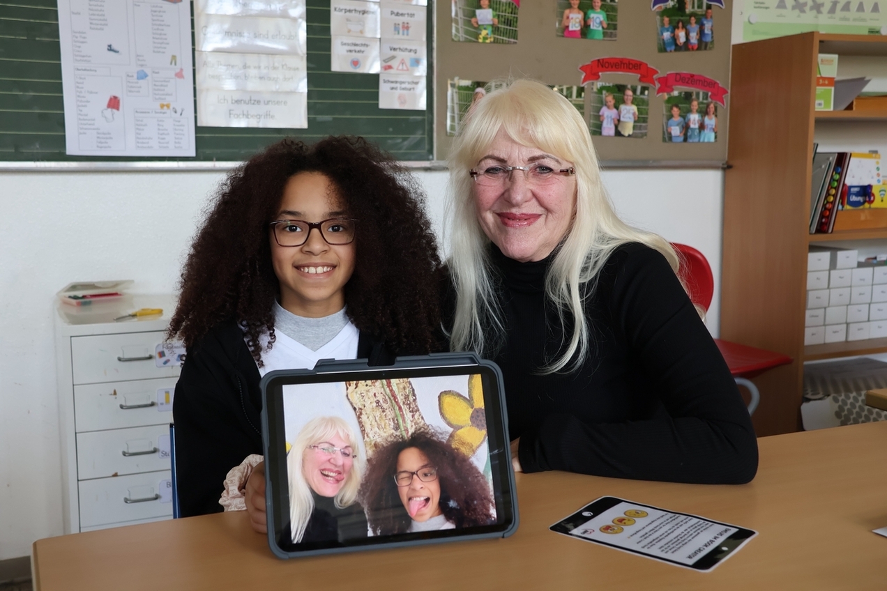 Oma Wali und die Viertklässlerin Jaydra stellten für das gemeinsame Fotobuch eine Reihe von Emojis nach, was ihnen sichtlich Spaß macht.