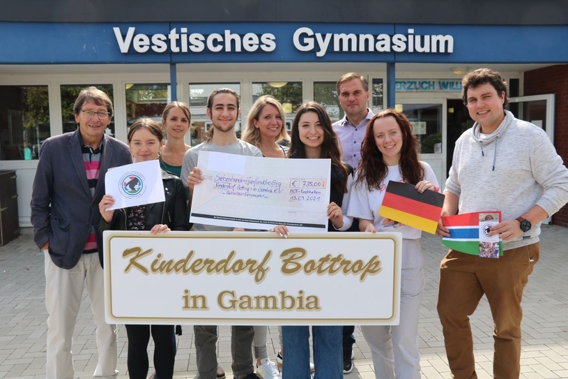 Der Schulleiter, die Schülervertretung, die AG-Lehrerin sowie vier Schüler übergeben den Spendenscheck an den Vorsitzenden des Vereins Kinderdorf Bottrop in Gambia, Wolfgang Gerrits (l.).