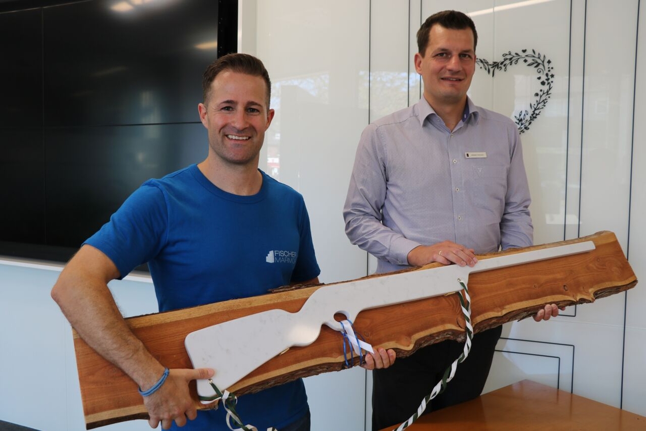 Björn Fischer, Geschäftsführer des Familienunternehmens Fischer Marmor, und Benedikt Risthaus, Private-Banking-Berater bei der Vereinten Volksbank (v.l.) präsentieren das nun in der Volksbank ausgestellte Marmor-Gewehr.